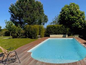 a swimming pool in a yard with a wooden deck at Chambre Terracotta privée et accès jacuzzi - sauna in Lézat-sur-Lèze