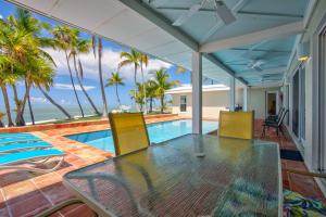 a patio with a table and chairs and a swimming pool at NEW!Paradise PointVIEWS!Open WaterDockPool! in Marathon