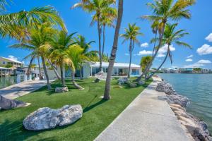 a walkway with palm trees and a house at NEW!Paradise PointVIEWS!Open WaterDockPool! in Marathon