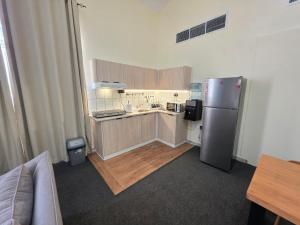 a kitchen with a stainless steel refrigerator in a room at Crescent by Oasis in Abu Dhabi +22 photos