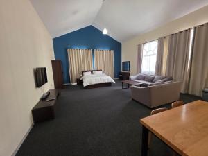 a large living room with a bed and a couch at Crescent by Oasis in Abu Dhabi