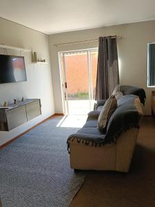 a living room with a couch and a large window at 5 Bayview Gonubie Seaside in Gonubie