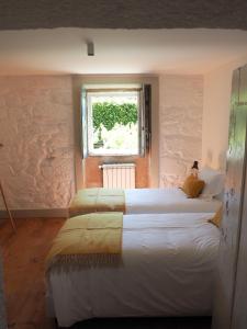 two beds in a room with a window at Quinta da Coutada - AgroTurismo in Arcos de Valdevez