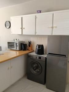 a kitchen with a washing machine and a microwave at 5 Bayview Gonubie Seaside in Gonubie