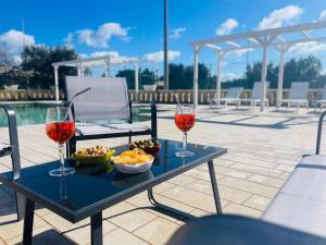 a table with two glasses of wine and a bowl of food at Dolce VillaCastelli in Villa Castelli