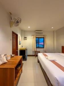 a bedroom with a bed and a desk and a television at Paihappyvillage in Pai +41 photos
