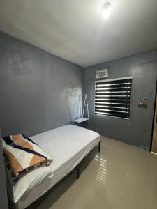a small bedroom with a bed and a window at Evas Inn in General Santos