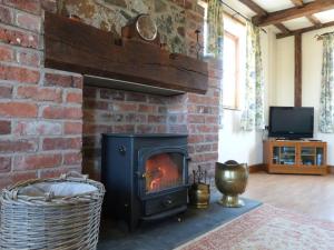 a brick fireplace with a stove in a room at 2 Bed in Welshpool oc-75703 in Meifod