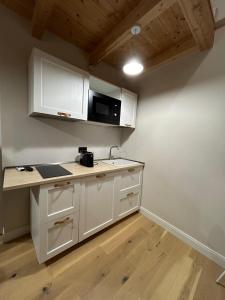 a kitchen with white cabinets and a microwave at Elisabetta1 Guesthouse Sassari in Sassari
