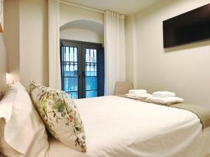 a bedroom with a large white bed and a television at Apt 1 hab Catedral III, Parking, Centro Valladolid in Valladolid