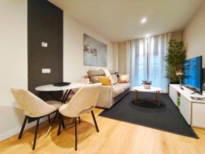 a living room with a couch and a table and chairs at Apt 1 hab Catedral III, Parking, Centro Valladolid in Valladolid