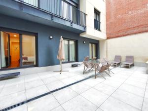 a patio with a table and chairs and a umbrella at Apt 2 hab Catedral II, Terraza, Parking, Centro in Valladolid