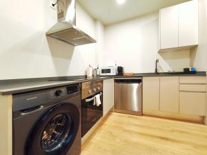a kitchen with a washing machine and a microwave at Apt 2 hab Catedral II, Terraza, Parking, Centro in Valladolid