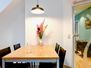 a dining room table with a vase of flowers on it at Altstadt Apartment für 6 Personen mit Stellplatz in Memmingen