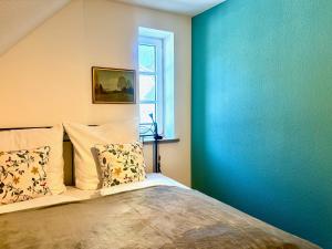 a bedroom with a bed with a blue wall at Altstadt Apartment für 6 Personen mit Stellplatz in Memmingen +7 photos