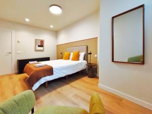 a bedroom with a large bed and two chairs at Apt 1 hab Catedral I, Centro Histórico in Valladolid