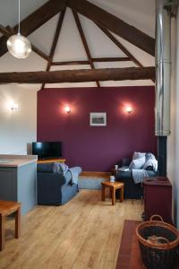 a living room with two blue couches and a purple wall at Vale Farm Cottages in Brecon