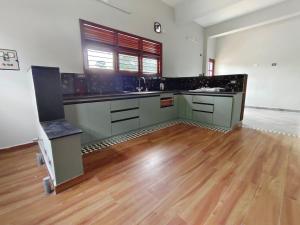 an empty kitchen with a wooden floor and counters at Desert Beach House with swimming pool in Kuilapayam