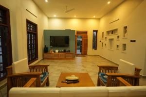 a living room with a table and chairs and a television at Desert Beach House with swimming pool in Kuilapayam