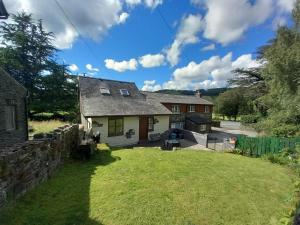 a house with a stone wall and a yard at 2 Bed in Machynlleth oc-wad305 in Cemmaes