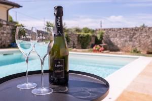 a bottle of wine and two glasses on a table at La Pria Wine Resort in Lonigo