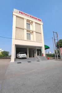 a white car parked in front of a building at HOTEL Prithvi Ratan in Utrāhtia