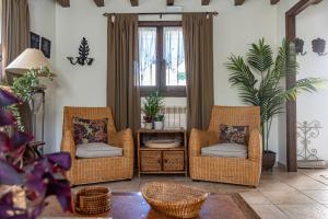 a living room with three wicker chairs and a table at Casa Rural Tío Conejo in San Román de Cameros