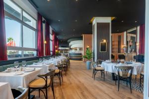 a dining room with white tables and chairs at Kenzi Solazur in Tangier