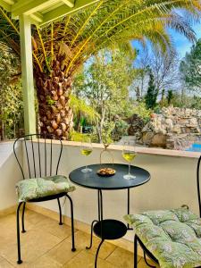 two chairs and a table with two glasses of wine at Kemerbag 29 Guest House 12 Yaş Üstü in Bozcaada