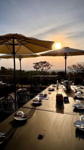 a long wooden table with umbrellas on top at Vinícola e Hospedaria Bonventi Ltda in Espirito Santo Do Pinhal