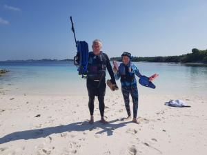 two people standing on the beach with their surfboards at Clove Beach in Addu Atoll