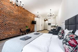 a bedroom with a brick wall and a large bed at Pod Błękitnymi Podkowami in Wrocław