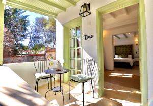 a porch with a table and chairs and a bedroom at Kemerbag 29 Guest House 12 Yaş Üstü in Bozcaada