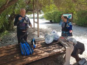 two men standing next to a park bench at Clove Beach in Addu Atoll