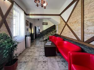 a red couch in a room with a brick wall at Садиба Буркут in Kvasy
