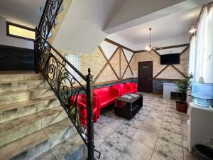 a living room with a red couch and stairs at Садиба Буркут in Kvasy