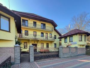 a yellow house with a balcony on the side of it at Садиба Буркут in Kvasy +34 photos