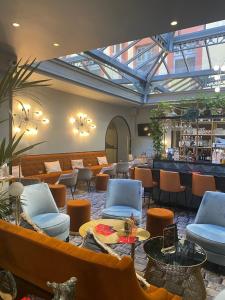 a lobby with couches and chairs and a bar at Hôtel Mercure Montauban in Montauban