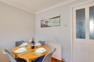 a dining room with a wooden table and chairs at 2 Bed in Newton oc-bow124 in Porthcawl +13 photos