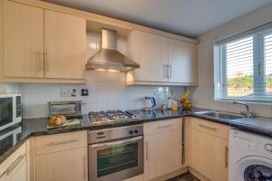 a kitchen with wooden cabinets and a stove top oven at 2 Bed in Newton oc-bow124 in Porthcawl