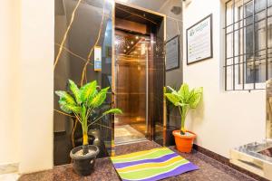 a hallway with plants and a towel on the floor at Treebo Sri Anand Residency in Chennai
