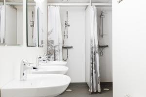 a white bathroom with three sinks and a shower at Trossö Vandrarhem in Karlskrona +55 photos