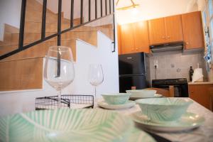 a kitchen with two wine glasses and plates on a table at anatoli by the sea in Skala Mistegnon
