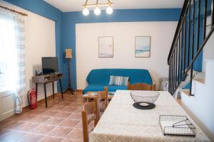 a living room with a table and a blue couch at anatoli by the sea in Skala Mistegnon