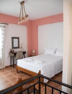 a bedroom with a white bed and a desk at anatoli by the sea in Skala Mistegnon