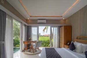 a bedroom with a bed and a desk and a window at Aksmi Suites & Villas in Bedahulu +51 photos