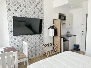 a bedroom with a bed and a tv on a wall at Woodland Tagaytay in Tagaytay