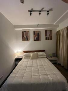a bedroom with a large white bed in a room at Woodland Tagaytay in Tagaytay
