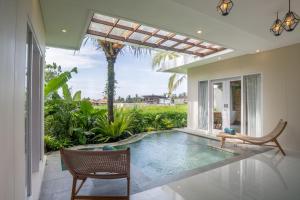 a swimming pool in the middle of a house at Aksmi Suites & Villas in Bedahulu