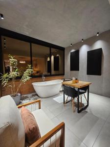 a large bathroom with a tub and a table at Vinícola e Hospedaria Bonventi Ltda in Espirito Santo Do Pinhal